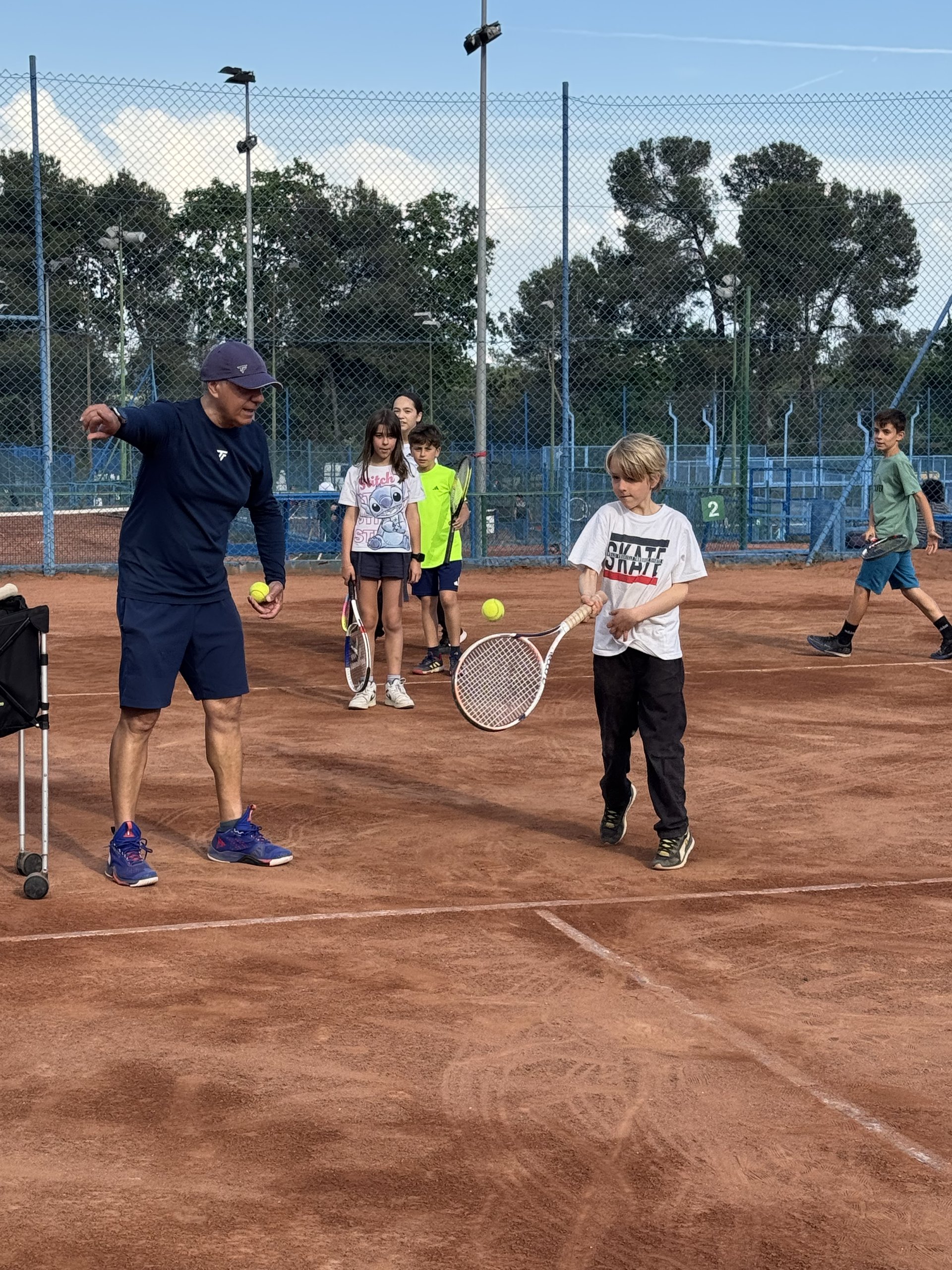 Monitor ensenyant tennis a nen